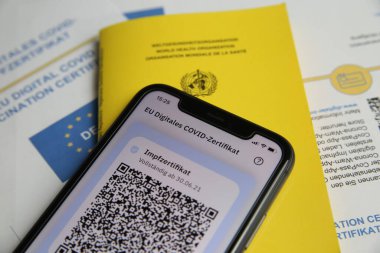 Viersen, Almanya - 24 Haziran. 2021: Cep telefonu ekranının dijital covid-19 aşı sertifikası ile kapatılması