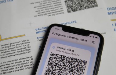 Viersen, Almanya - 24 Haziran. 2021: Cep telefonu ekranının dijital covid-19 aşı sertifikası ile kapatılması
