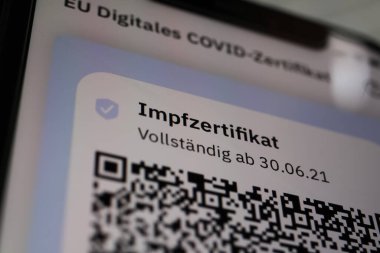 Viersen, Almanya - 24 Haziran. 2021: Cep telefonu ekranının dijital covid-19 aşı sertifikası ile kapatılması