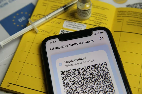 Viersen, Almanya - 24 Haziran. 2021: Cep telefonu ekranının dijital covid-19 aşı sertifikası ile kapatılması