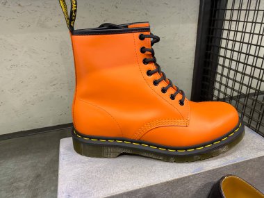 Roermond, Hollanda - 1 Haziran. 2021: Dr. Martens mağazasının rafında tek bir turuncu ayakkabının kapanışı