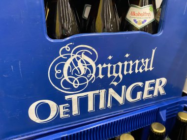 Viersen, Almanya - 1 Temmuz. 2021: Alman süpermarketindeki orijinal Oettinger bira fabrikasının logo harfleriyle mavi bira kasasının kapatılması