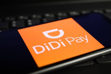 Viersen, Germany - June 1. 2021: Closeup of mobile phone screen with logo lettering of didi pay on computer keyboard clipart