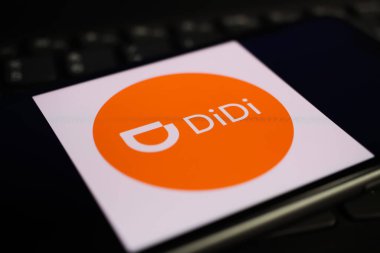 Viersen, Germany - June 1. 2021: Closeup of mobile phone screen with logo lettering of didi pay on computer keyboard clipart