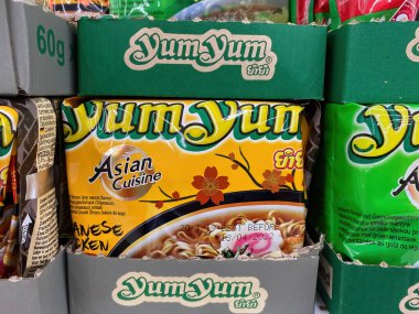 Viersen, Germany - June 9. 2021: Closeup of packets with logo lettering of yum yum instant noodles in shelf of german supermarket (focus on center of yellow packet)