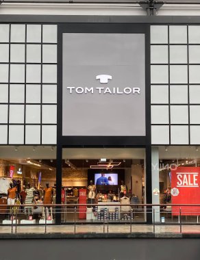 Oberhausen, Almanya - 9 Temmuz. 2021: Alışveriş merkezindeki Tom Taylor modasının logo harfleriyle mağaza girişine bakın