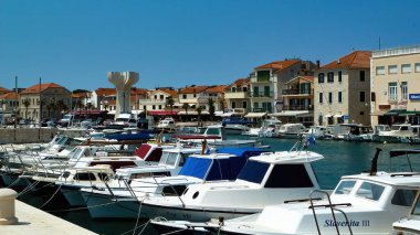 Vodice, Hırvatistan - 9 Mayıs. 2017: Mavi yaz gökyüzüne karşı eski ortaçağ adriyatik köyünün şehir manzarasında bulunan teknelerle liman manzarası
