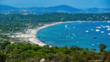 Panoramik manzara Akdeniz körfezi mavi yaz gökyüzüne karşı tekneler ve arka planda dağlar - Plage de pampelonne, St. Tropez (aşağı üçüncü bölgeye odaklan)