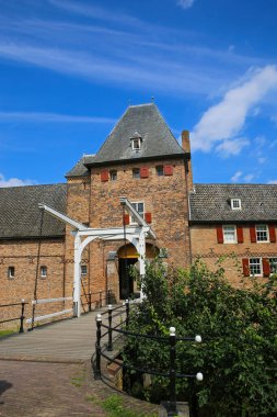 14. yüzyıldan kalma ortaçağ Hollandalı şatosunun mavi gökyüzüne karşı asma köprü ve hendeği olan Kasteel Kapısı, Hollanda