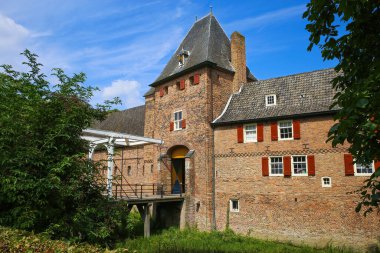 14. yüzyıldan kalma ortaçağ Hollandalı şatosunun mavi gökyüzüne karşı asma köprü ve hendeği olan Kasteel Kapısı, Hollanda