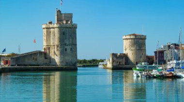 La Rochelle, Fransa - 9 Eylül. 2016: Mavi yaz gökyüzüne karşı iki ortaçağ kuleli liman girişi görülüyor