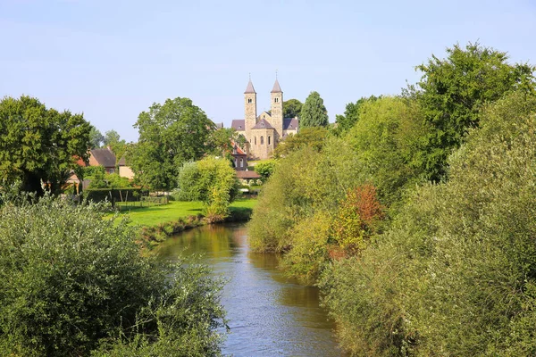青い夏の空に対して11世紀から修道院とローマのカトリック大聖堂で緑の木々と小さな川のローアを見下ろす セント オディレンベルク ローモンド近く オランダ — ストック写真