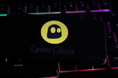 Viersen, Almanya - 9 Mayıs. 2021: Cep telefonu ekranında, bilgisayar klavyesinde VPN hizmeti siber hayaletinin logosu ile görüntüle