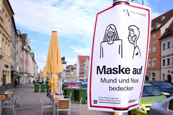 Augsburg, Maximilianstrae 'de yol kenarında bir tabela var. Bu da tüm vatandaşlar için bir maske gerektiğini gösteriyor. Sokakta pek bir şey olmuyor..