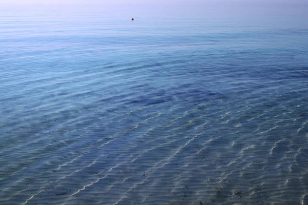 波にゆらゆらと揺れる青い水の背景と食感と太陽の光に照らされる — ストック写真
