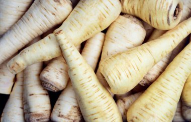 Pazarda satılık maydanoz kökleri üst üste duruyor.