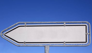 Beyaz yıpranmış bir işaret mavi gökyüzüne karşı bir ok şeklinde metin için yeri olan.