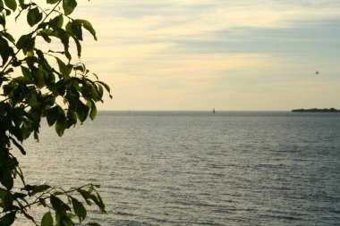 Körfezde gün batımı, bulutlu gökyüzü