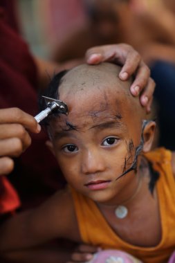 kimliği belirsiz bir Birmanya acemi bir Budist acemi hood inisiyasyon töreninde traş