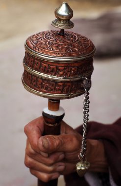 Buddhist monk with a prayer wheel clipart