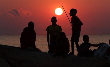 A group of fishermen and kids at sunrise,