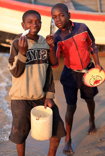 Boys offering fish at the beach — Stock Fotó