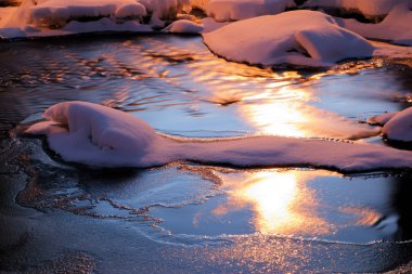 Snake like snow figure in the middle of the icy river clipart