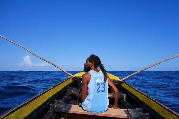 Rasta fisherman in a wooden boat in Port Antonio, Jamaica