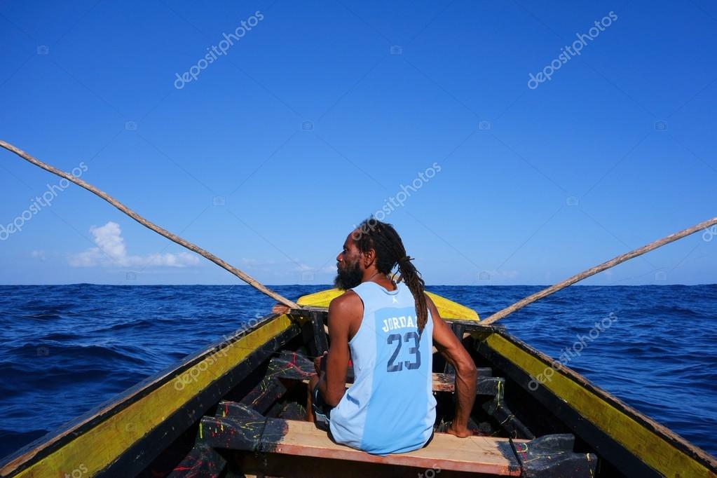 Port Antonio, Jamaica - December 31: fisherman in a traditional wooden fishing boat on New Years Eve December 21, 2013 in Port Antonio, Jamaica.