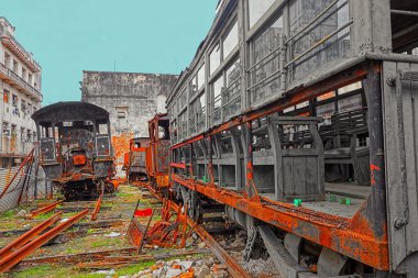 Paslı eski lokomotifler ve tren vagonları Havana, Küba'da bahçede