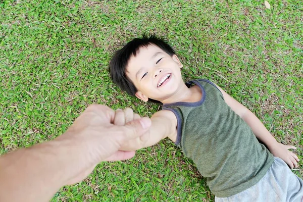 Little Asian Boy Laying Lawn Happily Blurry Hand Father Takes — Stock Photo, Image