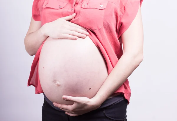 Pancia di donna incinta con rosso — Foto Stock