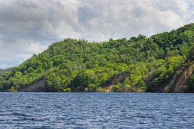 yaz gününde yeşil ağaçlar ile nehir kıyısında. Bulutlarla mavi gökyüzü