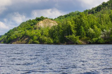 yaz gününde yeşil ağaçlar ile nehir kıyısında. Bulutlarla mavi gökyüzü