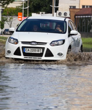 Cherkassy, Ukrayna - 5 Haziran 2016: araba sürüş su dolu bir yolda ağır yağmur, Cherkassy kaynaklanan bir sel sırasında.