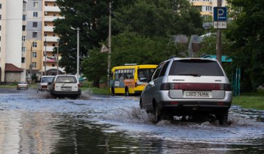 Cherkassy, Ukrayna - 5 Haziran 2016: araba sürüş su dolu bir yolda ağır yağmur, Cherkassy kaynaklanan bir sel sırasında.