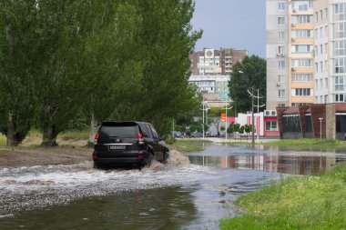 Cherkassy, Ukrayna - 5 Haziran 2016: araba sürüş su dolu bir yolda ağır yağmur, Cherkassy kaynaklanan bir sel sırasında.