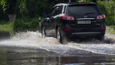 Cherkassy, Ukrayna - 5 Haziran 2016: arabalar neden ağır yağmur, Cherkassy sonra bir sel sırasında su dolu bir yolda sürüş.