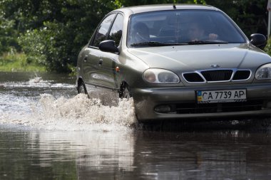 Cherkassy, Ukrayna - 5 Haziran 2016: arabalar neden ağır yağmur, Cherkassy sonra bir sel sırasında su dolu bir yolda sürüş.