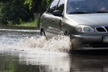 Cherkassy, Ukrayna - 5 Haziran 2016: arabalar neden ağır yağmur, Cherkassy sonra bir sel sırasında su dolu bir yolda sürüş.