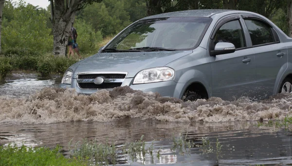 CHERKASSY, UKRAINE- JUNHO 5, 2016: carros que conduzem em uma estrada inundada durante uma inundação causada por chuvas fortes, em Cherkassy . — Fotografia de Stock