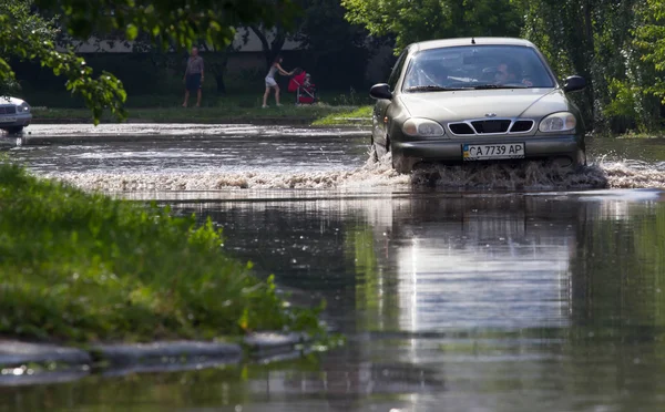 CHERKASSY, UKRAINE- JUNHO 5, 2016: carros que conduzem em uma estrada inundada durante uma inundação causada por chuvas fortes, em Cherkassy . — Fotografia de Stock