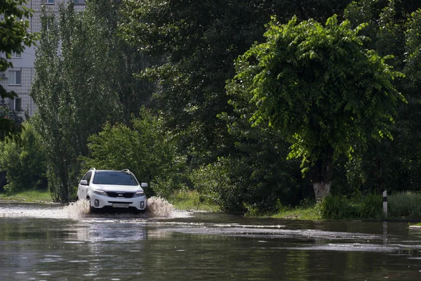 Tscherkassy, Ukraine - 5. Juni 2016: Autos fahren auf einer überfluteten Straße während einer Überschwemmung, die nach starkem Regen verursacht wurde, in Tscherkassy. — Stockfoto