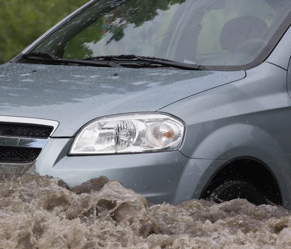 Автомобілі, що їздять по затопленій дорозі під час повені, викликаної сильним дощем — стокове фото