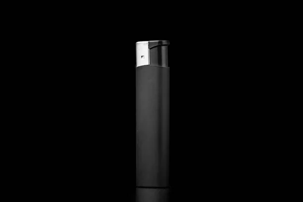 Isqueiro de cigarro em um fundo preto no escuro — Fotografia de Stock