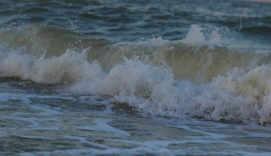 Denizde fırtınalı gün batımı. Dalga ve splash