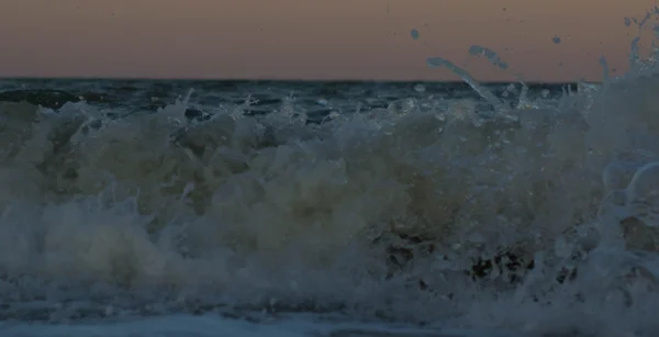 O pôr-do-sol tempestuoso no mar. Onda e salpicos — Fotografia de Stock