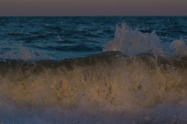 O pôr-do-sol tempestuoso no mar. Onda e salpicos — Fotografia de Stock