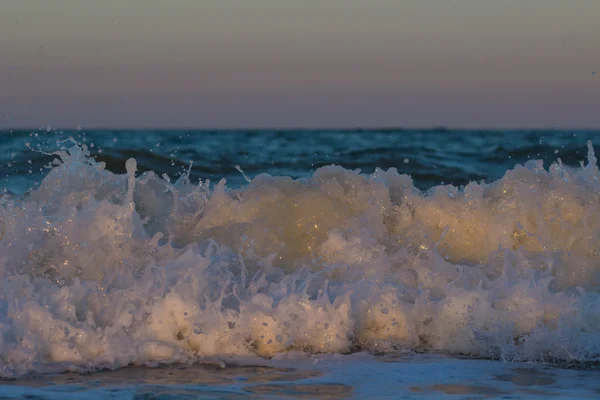 O pôr-do-sol tempestuoso no mar. Onda e salpicos — Fotografia de Stock