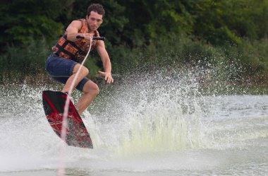 Yeşil parkta gölet erkek wakeboarder.